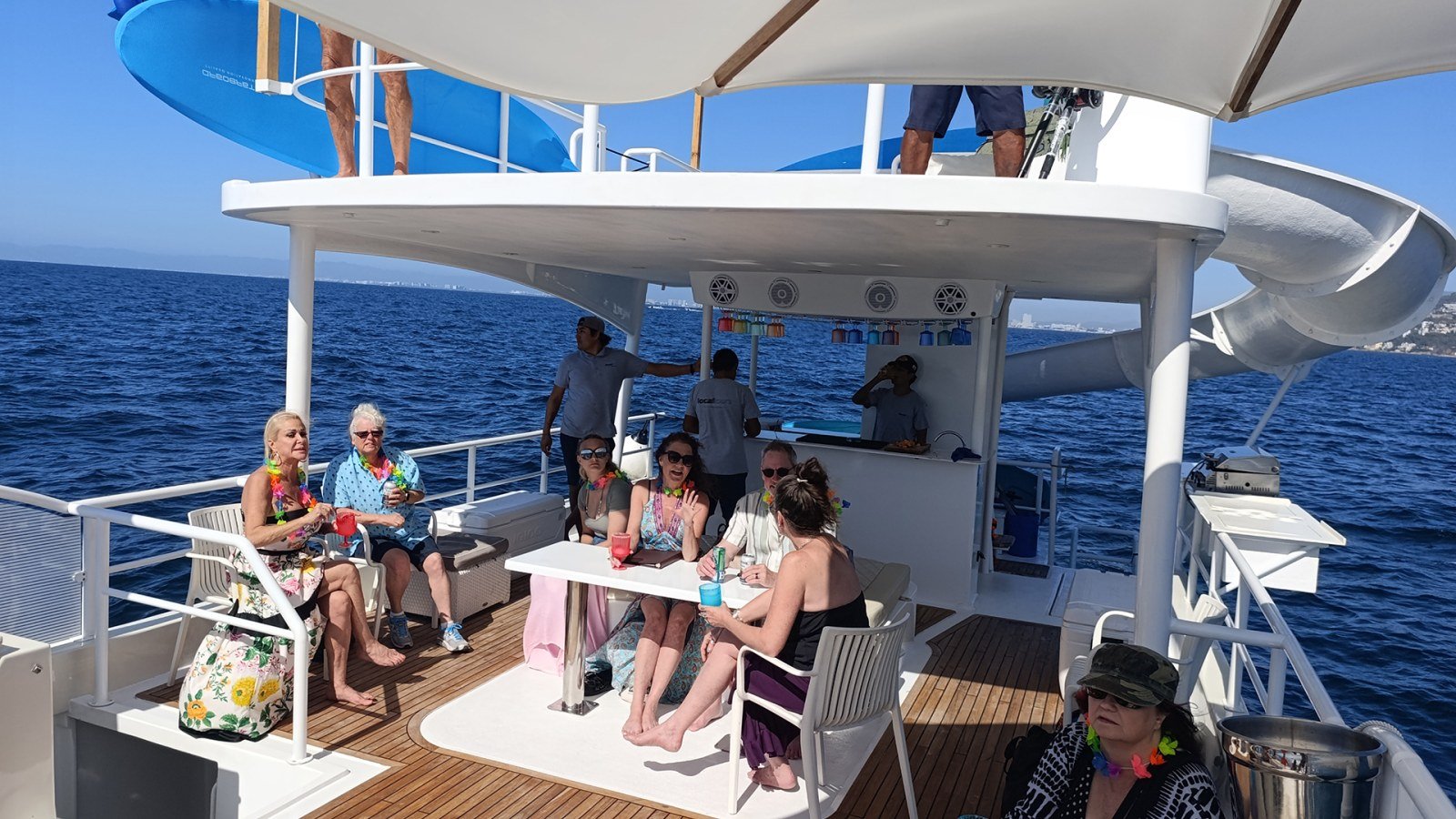 A group of guests relaxing on the shaded deck of the 45 ft party catamaran on a Puerto Vallarta charter